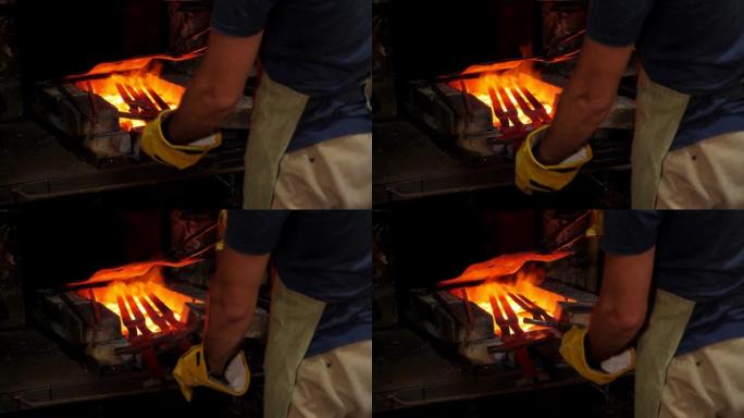 一个铁匠把两把炽热的金属剑放在燃烧的煤上。