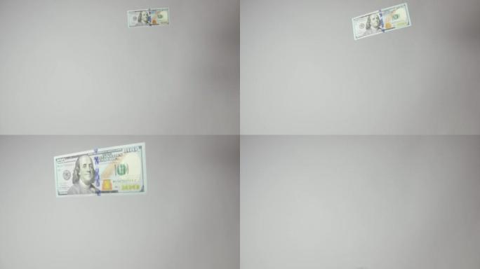 美国一百美元的钞票向摄像机向下翻转，向左退出帧