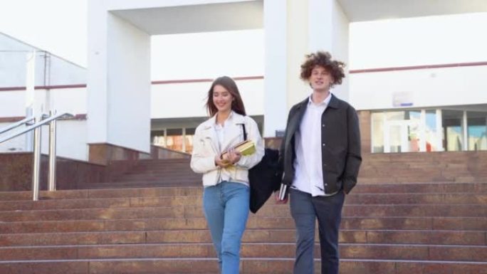 两个时髦的学生走在校园附近，微笑着。友好的白人男孩和女孩一起走在大学附近