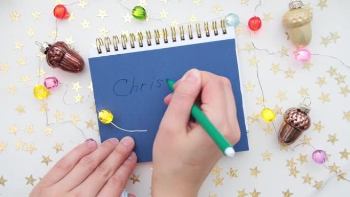 女性手握笔，打开空白记事本进行书写。圣诞节或新年愿望或支票清单。