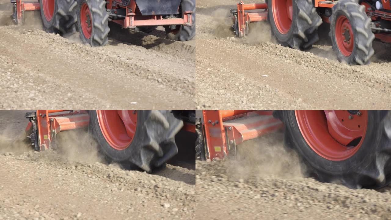 拖拉机在农场用旋耕机耕种土地。