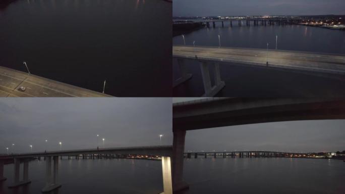 无人驾驶飞机拍摄黄昏时在阴暗的天空下在宁静的湖上的一座长桥