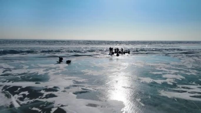 站在冰冻湖上的旅行者团体的剪影。商业旅游