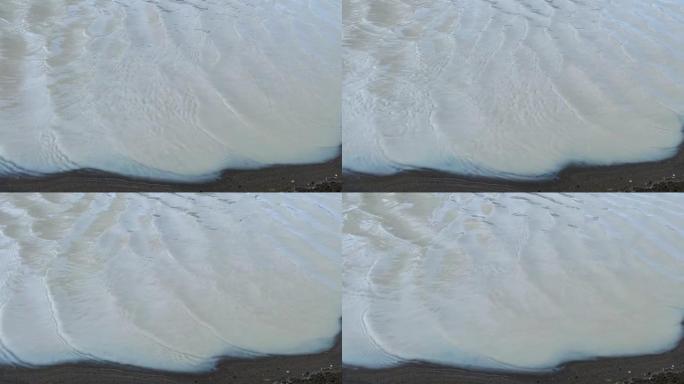 小波浪，沙滩上的软波浪，用于打开视频，文本空间。白色沙滩，沙滩上的海浪