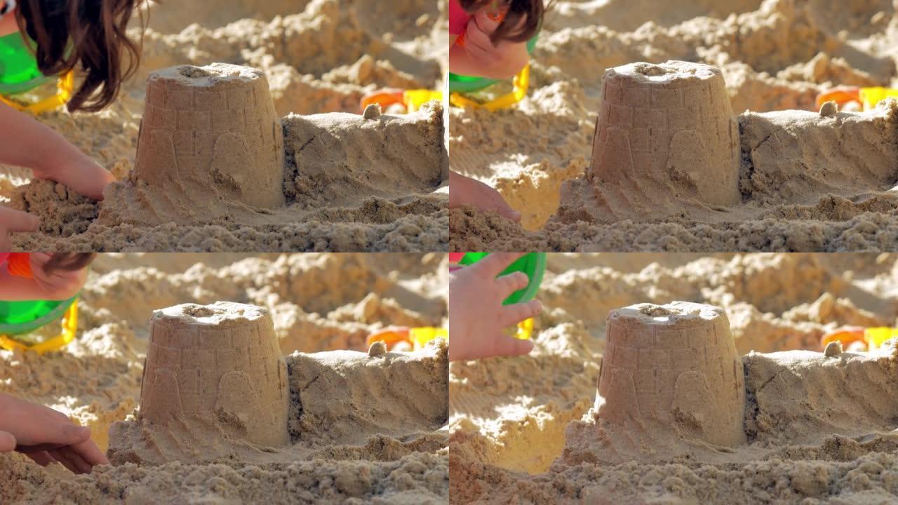 特写，一个沙饼，孩子的手在上面放一个沙子的表格。操场上或沙滩上的夏季儿童游戏