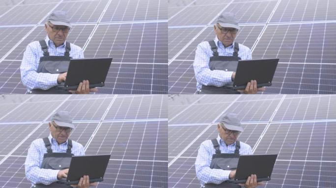 工程师在太阳能电池板前的笔记本电脑上工作。
