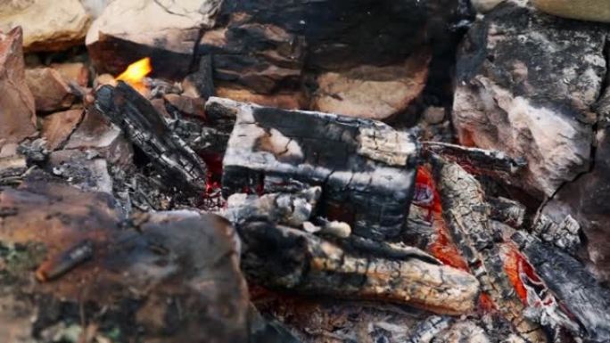 特写镜头中燃烧着的篝火，烧着阴燃的煤。顶视图。野餐和烧烤。壁炉的温暖