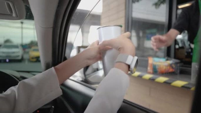 美丽的女人向员工发送个性化的咖啡杯或杯子，开车经过或开车经过。