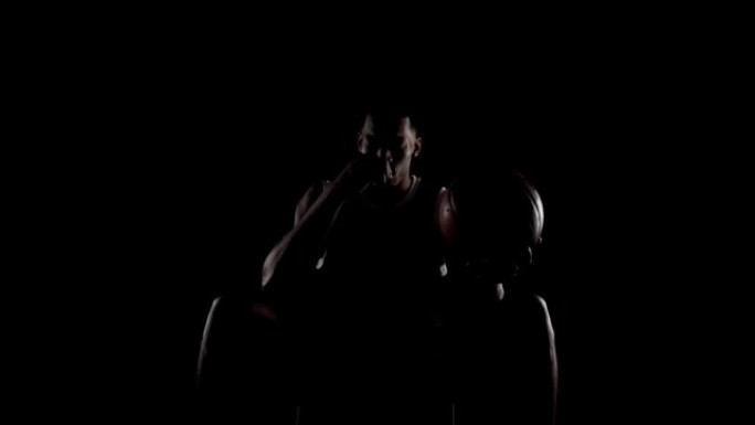 篮球运动员坐在长凳上祈祷。黑人背景下的宗教非洲裔美国体育人。