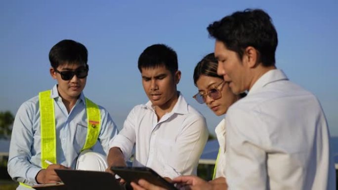 特写镜头，一组亚洲工程团队在计划操作和车站光伏太阳能电池板期间使用笔记本电脑，年轻的检查员工程师男性