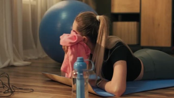 苗条的健身马尾辫年轻女孩在家庭体操室内做铺板运动