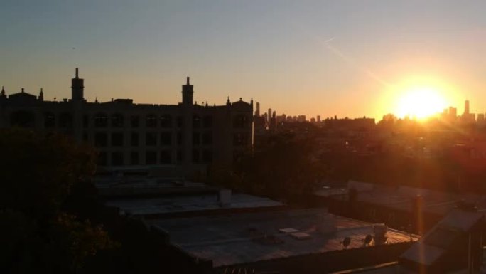 日落时住宅建筑物屋顶上方的空中无人机镜头