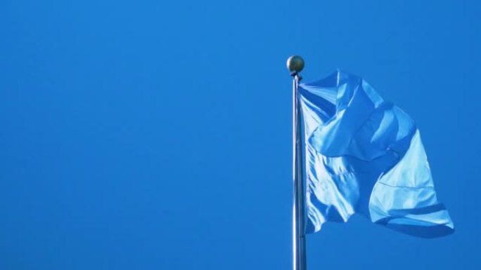 联合国国旗在纽约总部的杆子上挥舞的慢动作