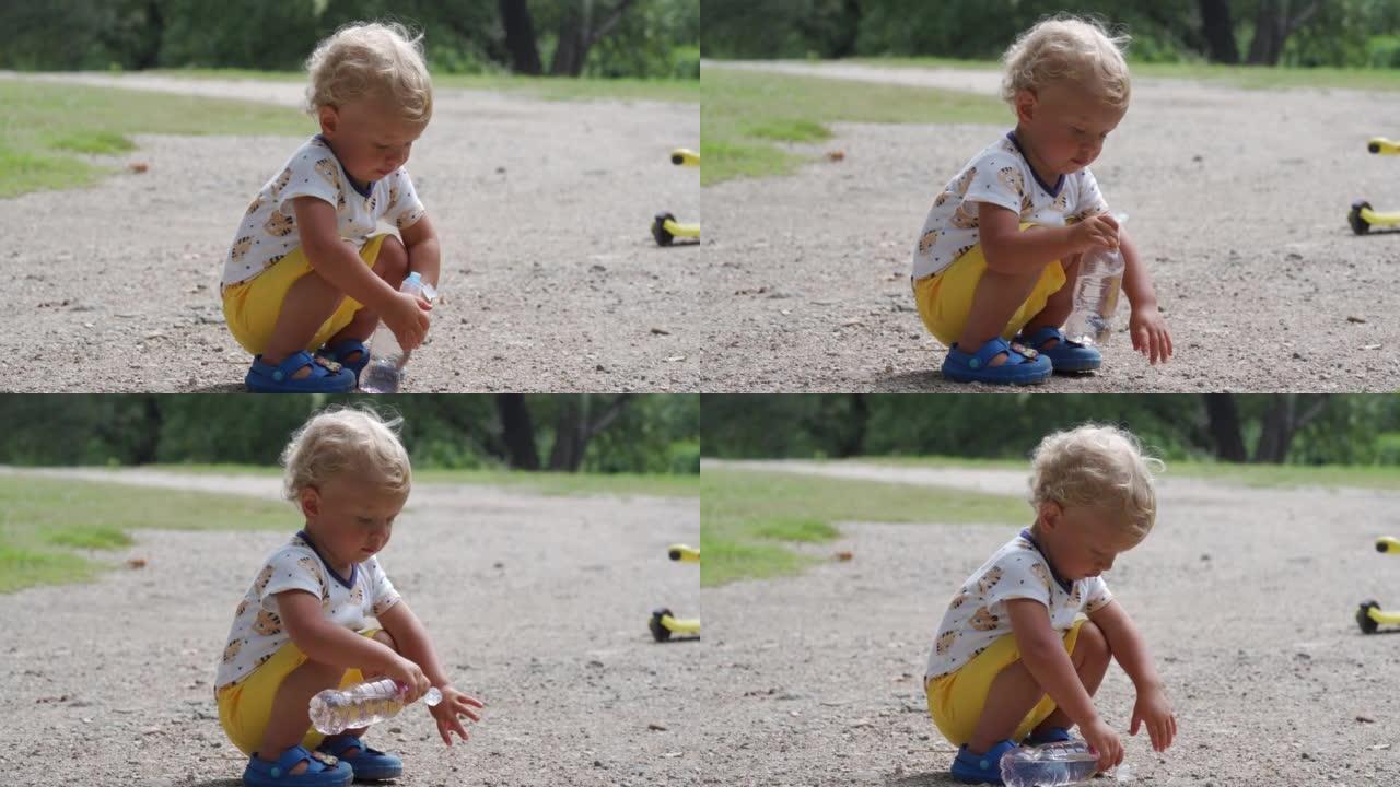 夏天，孩子从公园的婴儿奶瓶中喝水，1.5岁的蹒跚学步的孩子在户外自然。