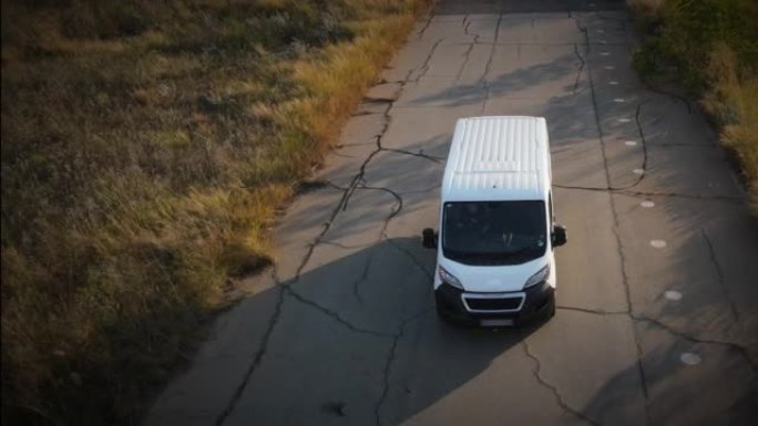 一辆白色货车在乡村道路上行驶的空中无人机镜头