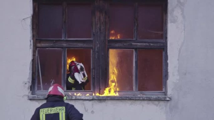 消防员英雄从火灾事故中从燃烧的建筑区域带走女婴。从危险的地方营救人们