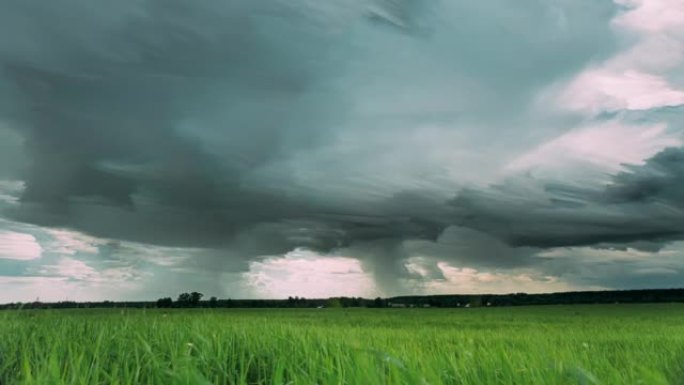 4k延时不寻常的云影响阴雨的天空，地平线上有雨云，乡村乡村田野景观上有年轻的绿色麦芽，春春夏日。云迹