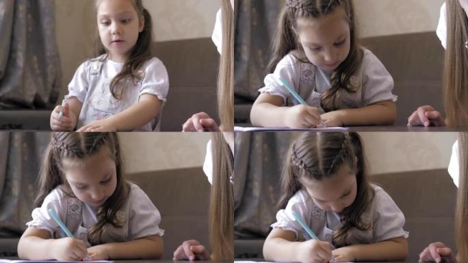 妈妈和她的学龄前女儿一起在家做作业，妈妈帮助5岁的女孩做学龄前任务，在笔记本上写信。儿童教育理念。支