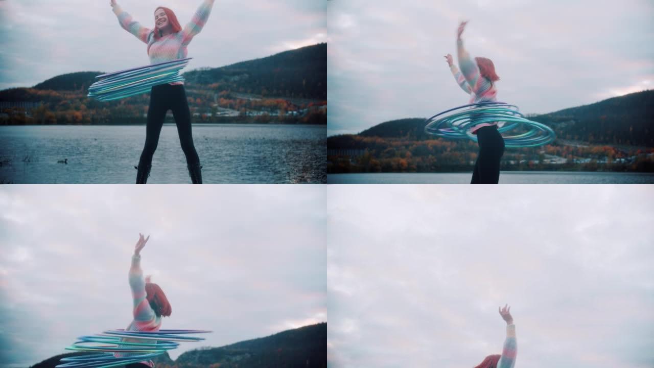 年轻的红发女孩在希尔湖附近的腰部旋转艺术体操圈