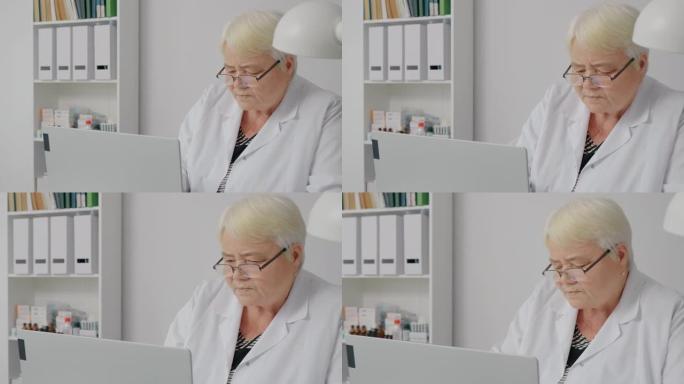 经验丰富的女医生在笔记本电脑中检查患者病史。