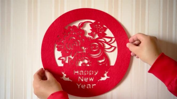 男子在水平构图的墙上贴了一个中国新年的兔子剪纸装饰