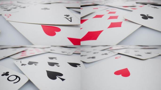 在白色的酒神地上玩牌。极其特写详细，随机躺着红心钻石套装的扑克牌。