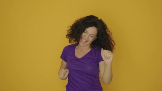 女人跳着欢喜，在黄色背景上跳舞。