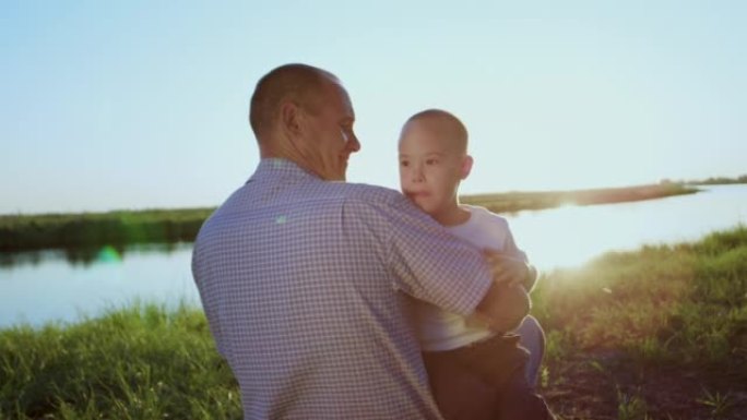 父亲在日落时抱着患有唐氏综合症的小儿子