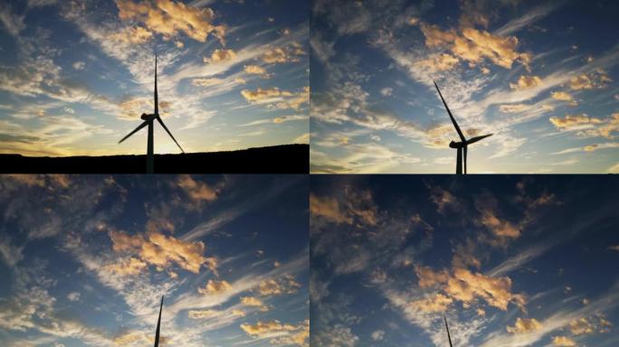 无人驾驶飞机在晚上五颜六色的日落时拍摄风力涡轮机。美丽多彩的多云天空。生产清洁绿色能源的风车。
