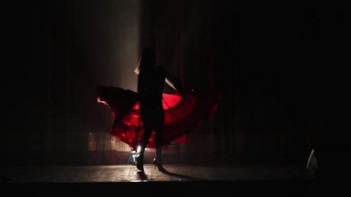 穿着红色背光舞蹈弗拉门戈连衣裙的美丽女性剪影