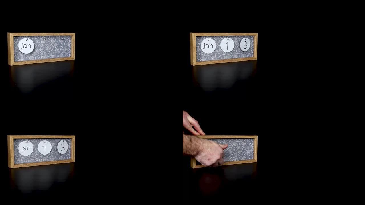 一个木制日历块，用男人的手1月13日和取下带有日期和月份的金属盘，以4k质量拍摄