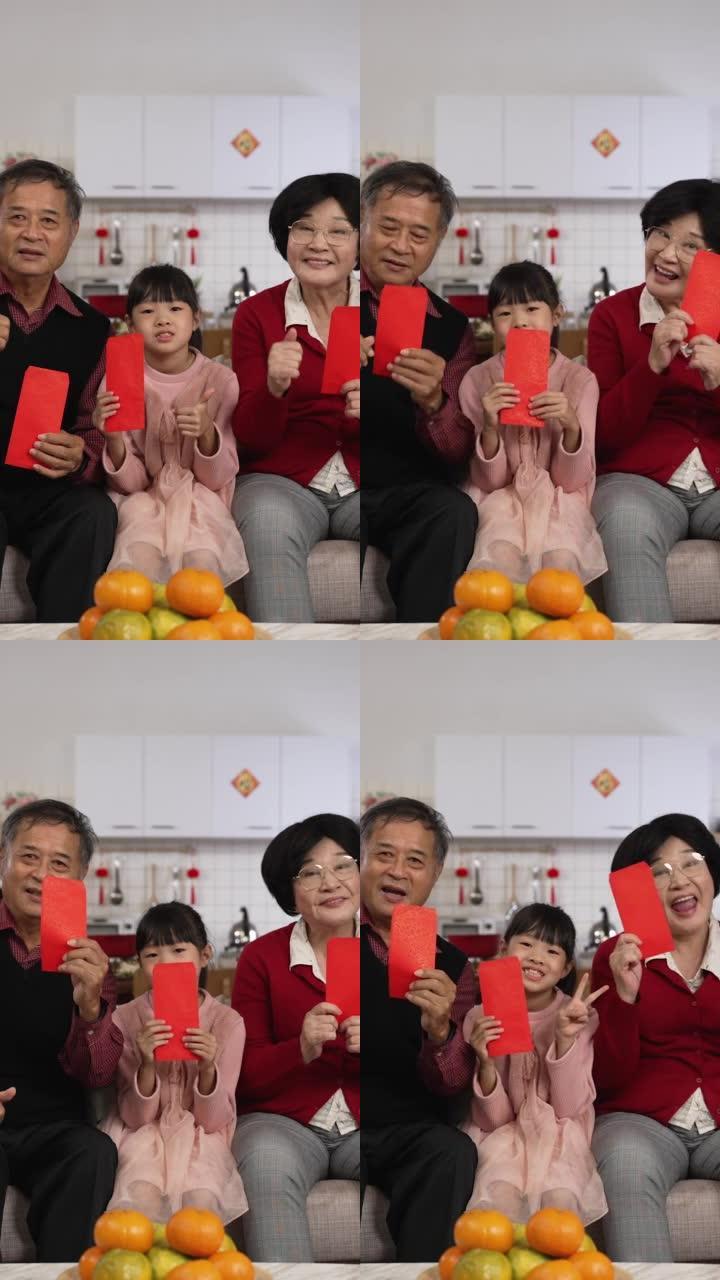 竖屏:中国农历新年，一家混血儿在家里用拇指和胜利的手势对着镜头微笑，用红包压岁钱拍爆棚照。翻译:幸运