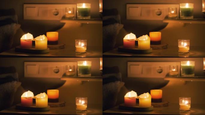 黑暗房间里的蜡烛。在桌子上燃烧蜡烛，在背景上燃烧插座。房子里没有电。城市停电。停电，能源危机概念