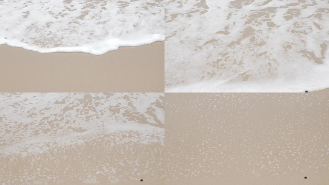 靠近海浪在细沙沙滩上滚动，海浪在白色沙滩上破裂，带有美丽的泡沫，热带暑假自然背景