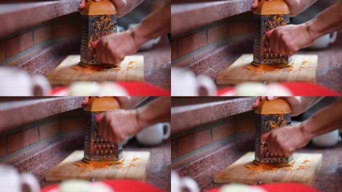 女人在刨丝器上手工切胡萝卜的特写镜头。