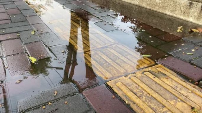 盲人在瓷砖路面上的触觉铺装。盲人人行道，雨后有水坑。