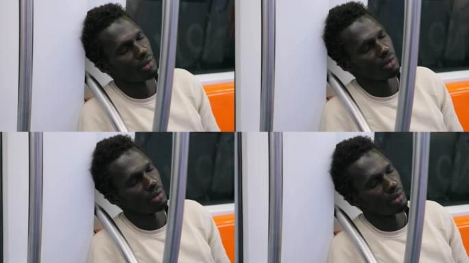 年轻的美国非洲裔男性在公共交通工具中疲倦而沮丧地睡着了