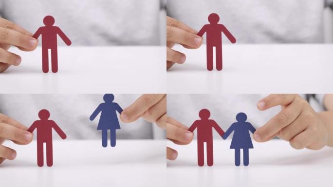 纸男人和女人在一个男孩的手中。