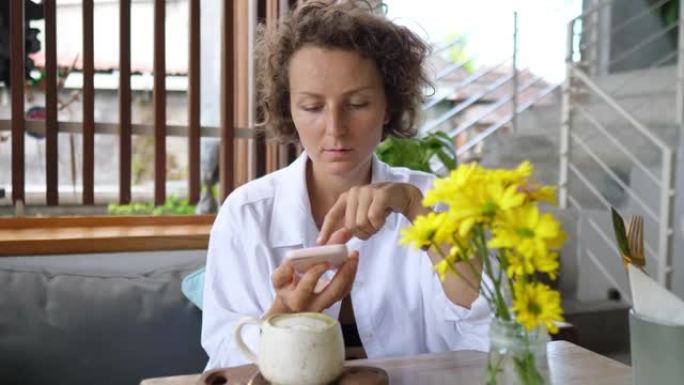 一位女性博客作者为她健康的抹茶拿铁茶拍照，并将镜头发布在她的博客上，以供订阅者和志同道合的人使用。她