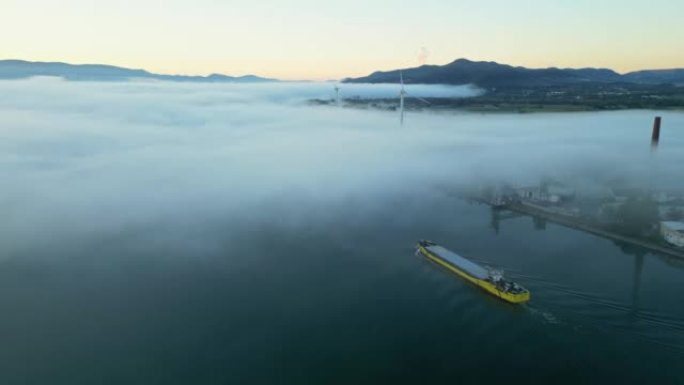 早晨，浓雾笼罩在罗纳河上的一艘客船的无人机的全景。在法国的Le Pouzin镇