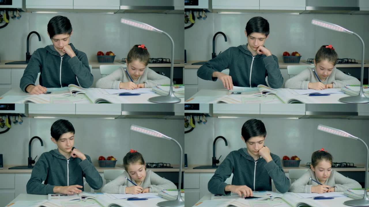 年轻的中学男孩和妹妹一起在家做作业