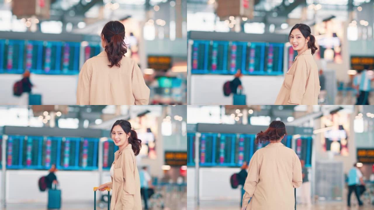 幸福微笑的亚洲女性乘客在机场航站楼带着行李箱行走。