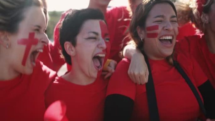 多代红色运动迷在支持他们的球队时尖叫-足球女支持者在比赛中玩耍-冠军和获胜概念