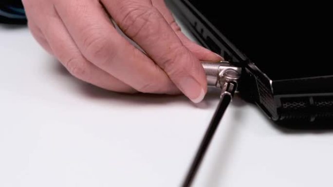 女人用电缆锁锁住笔记本电脑。肯辛顿安全槽。工作场所安全概念。