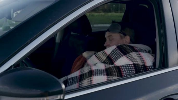 司机戴上面具遮住眼睛，用毯子盖住自己。