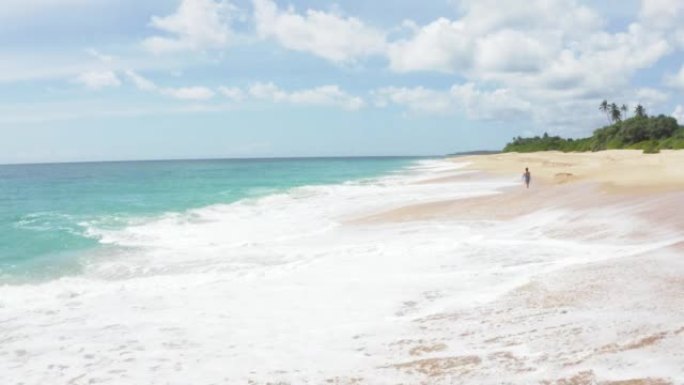 沙滩上的脚印。孤独的女人赤脚走在印度洋沙滩上，大浪享受孤独。斯里兰卡Tangalle附近的4k动态镜