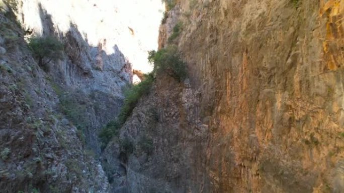 峡谷中的极端空中飞行无人机在岩石之间飞行鸟瞰峡谷