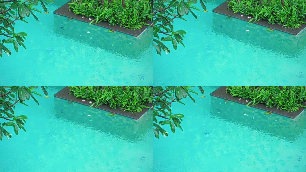 雨滴落在泰国酒店游泳池的蓝色水中