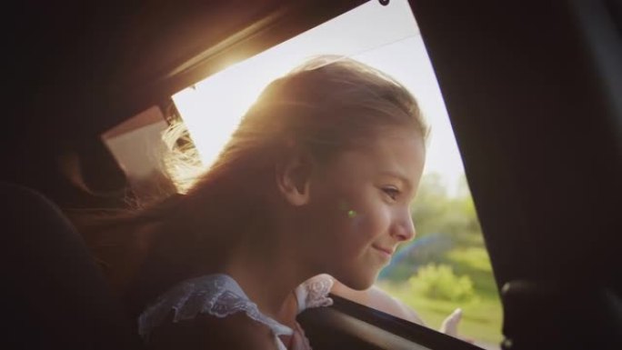无忧无虑的小女孩把头伸出敞开的车窗