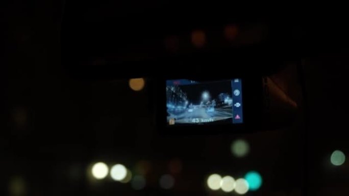 数字录像机在车里工作。汽车在夜城移动。大城市的夜灯